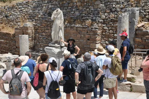 Nuestro guía explica la historia de una estatua romana a un grupo atento en Éfeso.